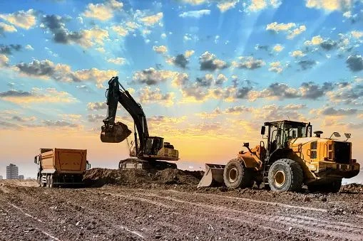 Excavator dan kendaraan pada area pekerjaan lahan